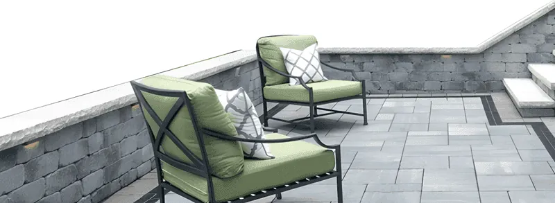 Gray paver patio enclosed by a seat wall
